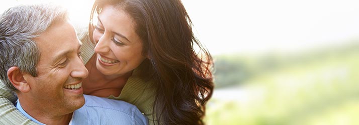 Chiropractic-Burbank-CA-Middle-Aged-Man-and-Woman-are-Smiling-at-Each-Other-While-Outside-in-a-Field.jpg low back pain relief with chiropractic care
